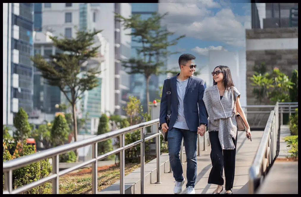 A man and woman walking down the sidewalk.