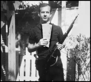 A man holding an ar-1 5 rifle and drinking coffee.