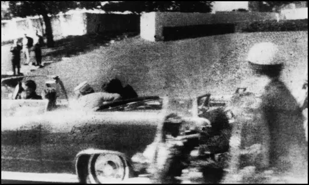 A black and white photo of cars in the street.