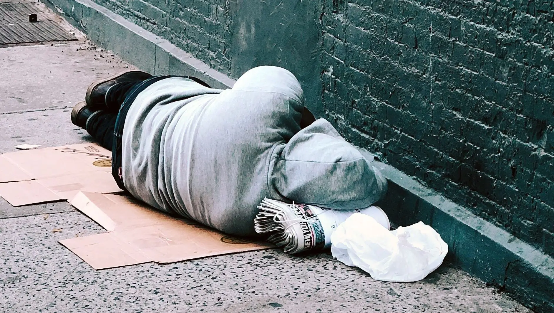 A person laying on the ground with their head down.