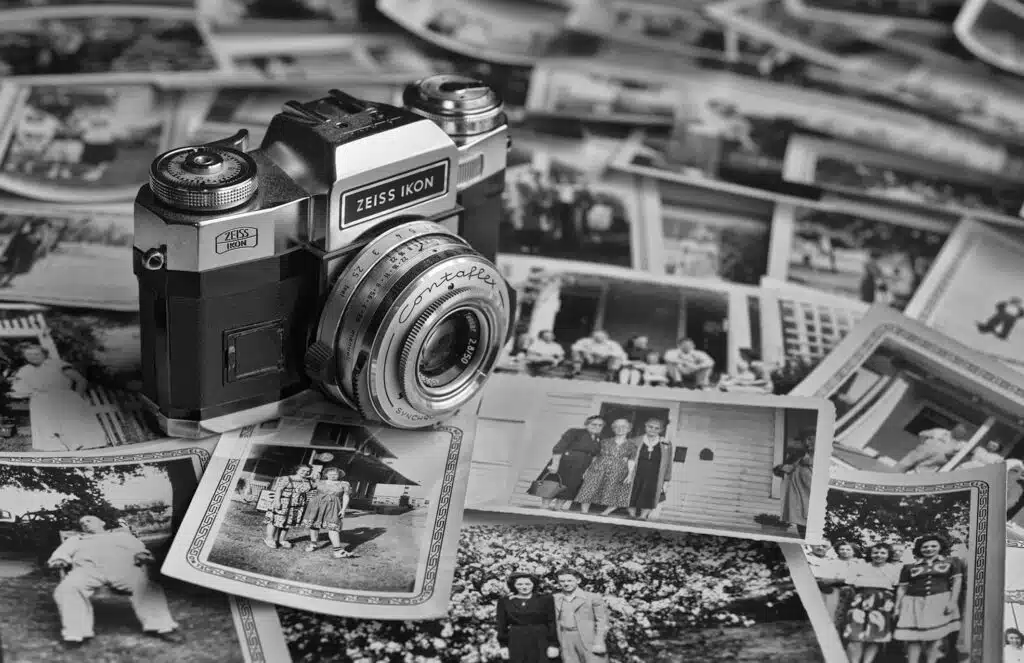 A camera sitting on top of some old photos.