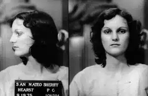 A black and white photo of a woman in a mug shot.