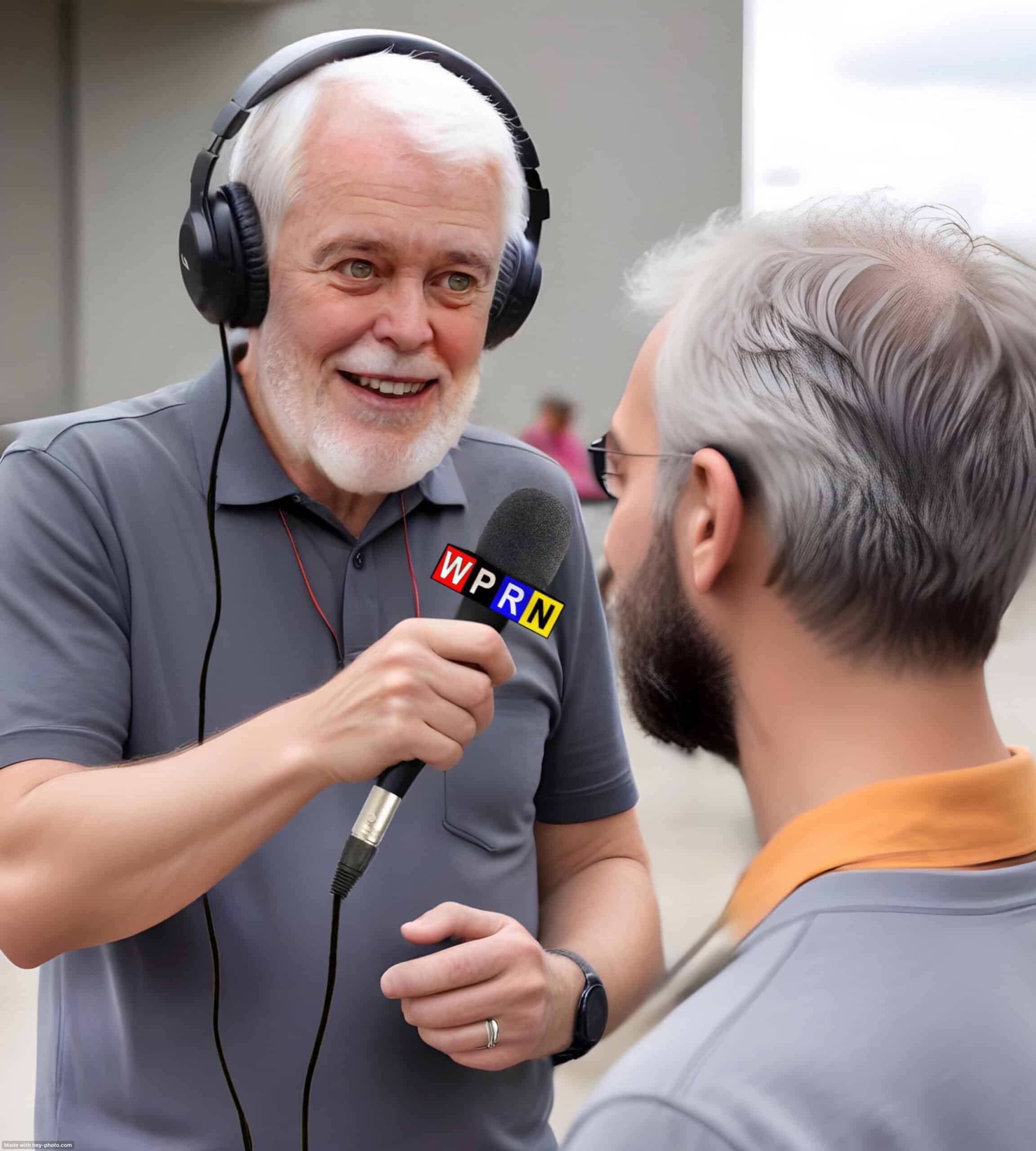 A man with headphones is talking to another man.