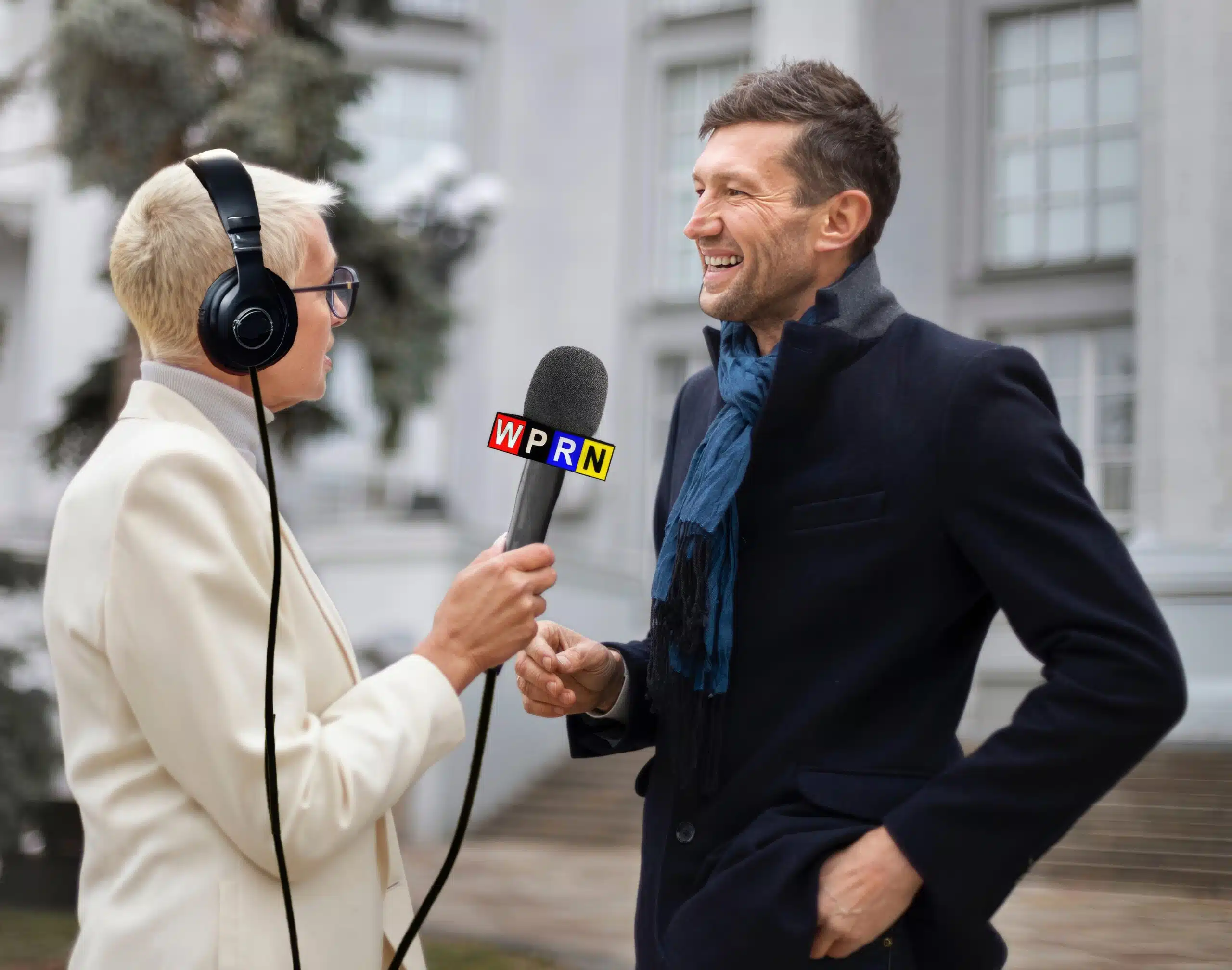 A man in a suit is being interviewed by an older woman.