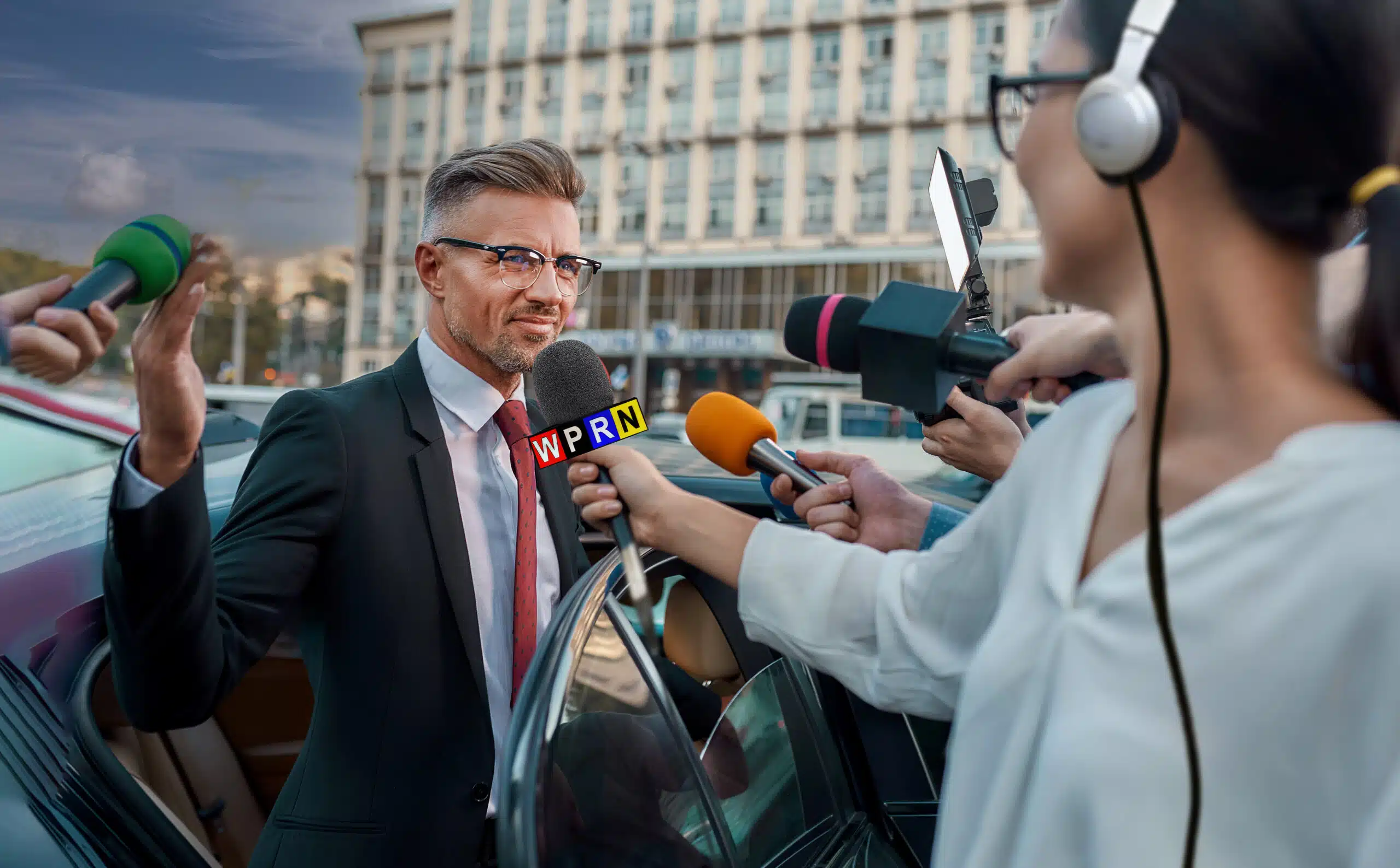 A man in a suit is being interviewed by a woman.