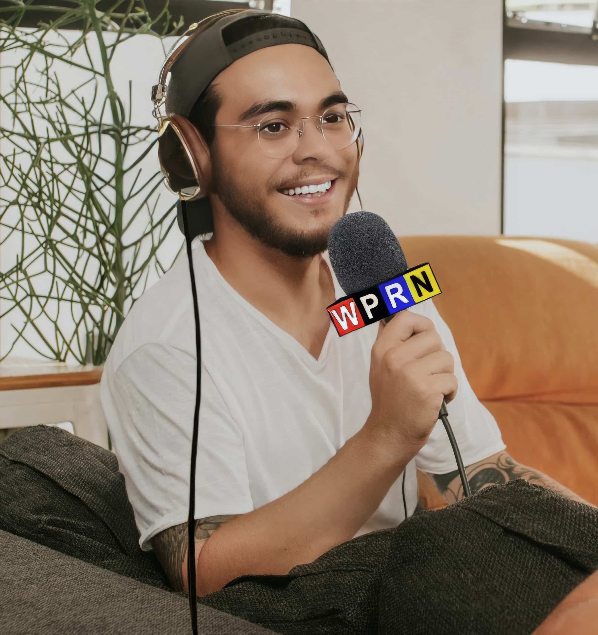 A man sitting on the couch with headphones and microphone.